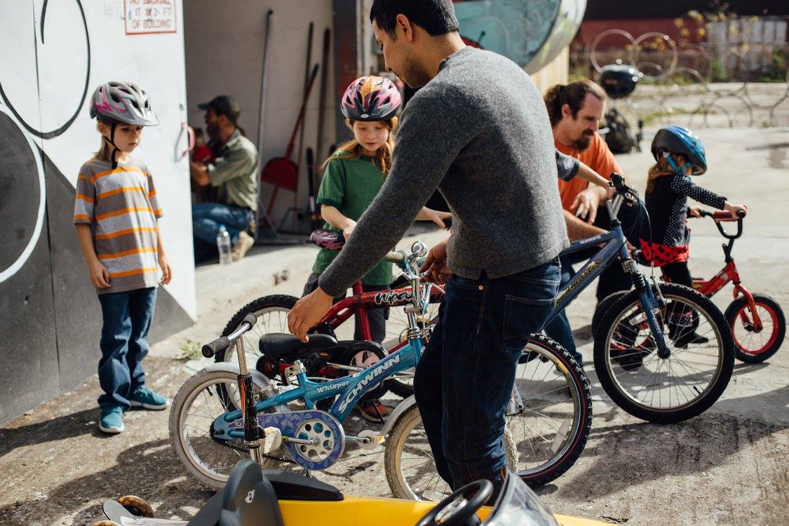 Volunteer assisting children with their bicycles