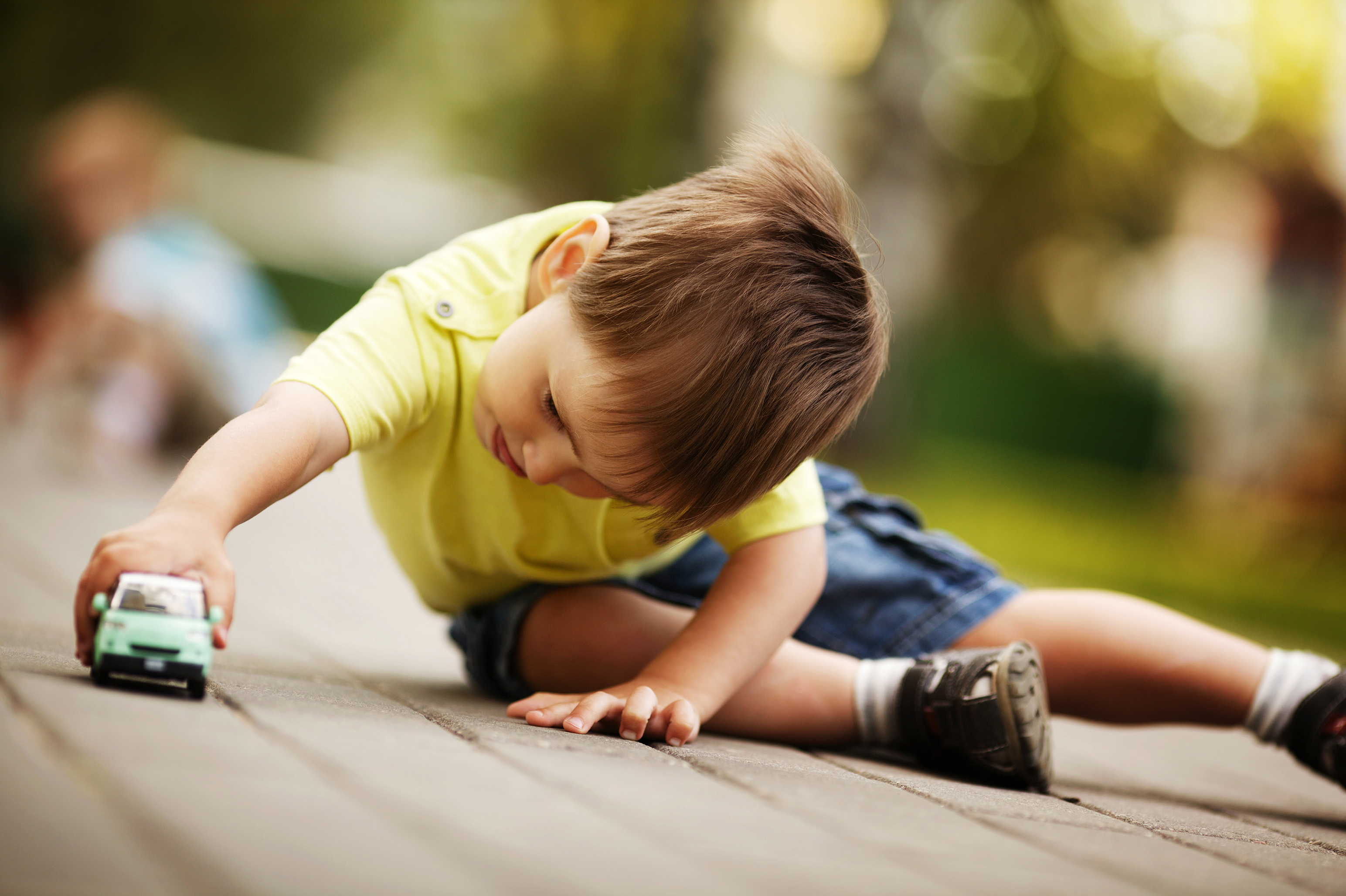 A young boy playing with a toy vehicle