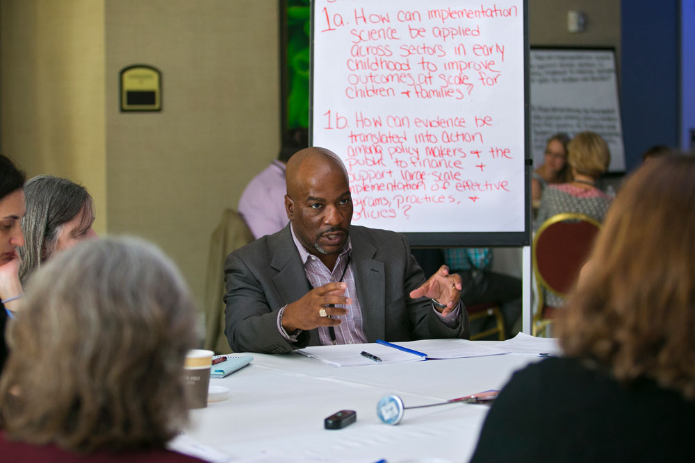 People at a table engaged in a discussion. 