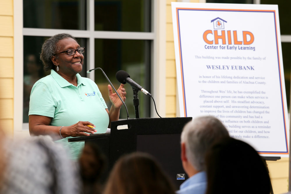 A woman at a podium speaking to a group.