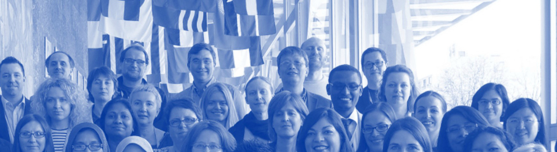 Brian Reichow in a group of people with flags in the background.