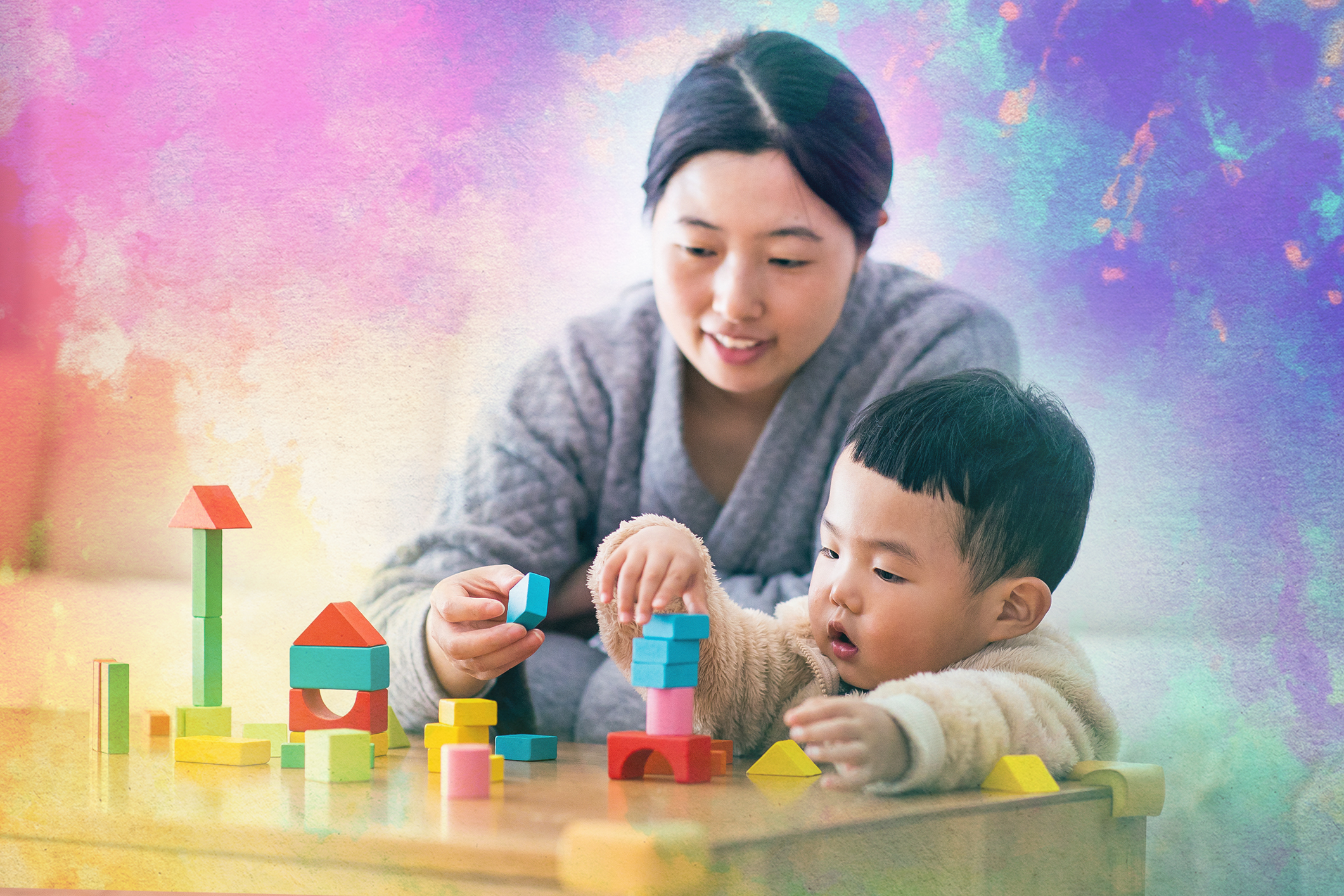 A parent playing with blocks with their child